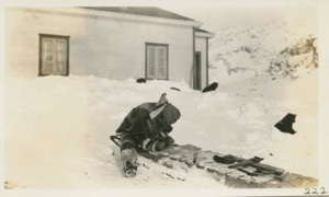 Image: To-ark-ta-ga mending a sledge at Amadjuak